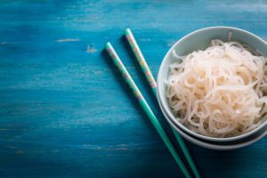 A bowl of konjac noodles against a blue background