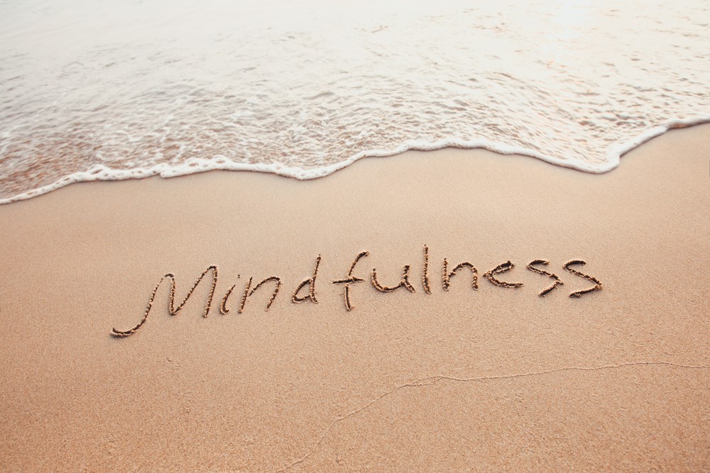 The word mindfulness written in the sand, highlighting mindfulness for seniors or caregivers