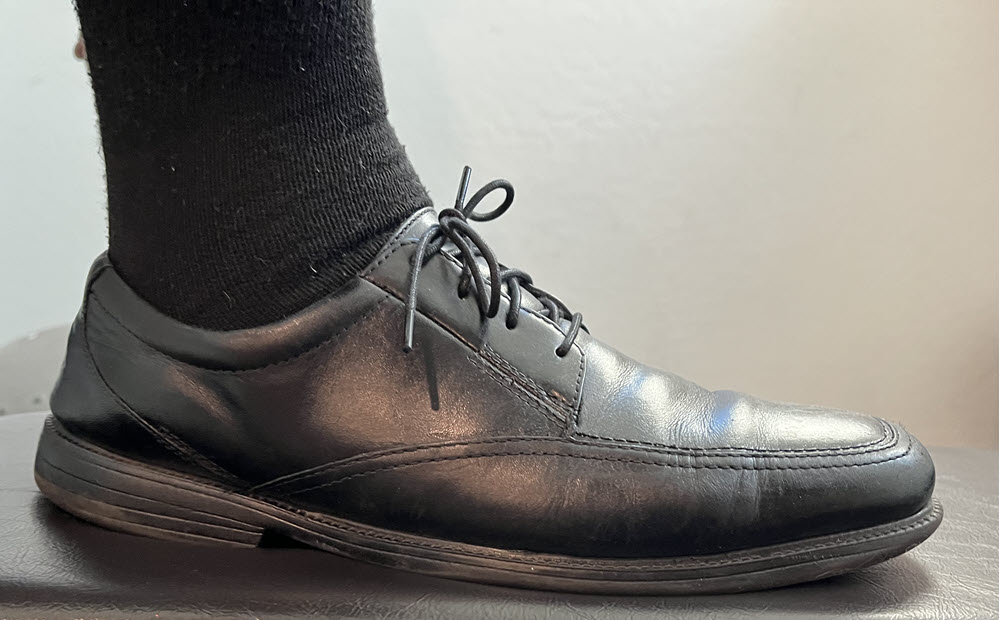 A man wearing black Dr. Scholl's socks with black dress shoes