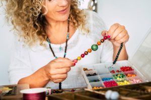 A woman beading, highlighting the idea of hobbies for caregivers