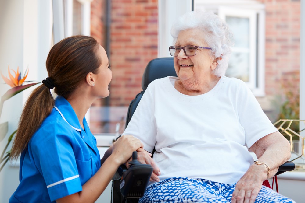 A woman in assisted living or a memory care facility talking to her nurse