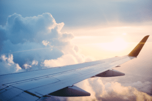 A plane wing over clouds, highlighting the idea of flying with seniors