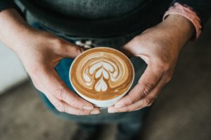Man holding a cup of coffee, highlighting coffee hacks