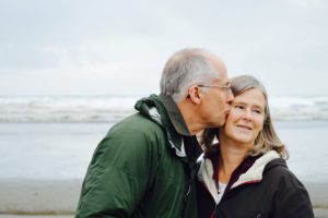 A senior couple happy on the beach, highlighting the question of - why retire abroad?