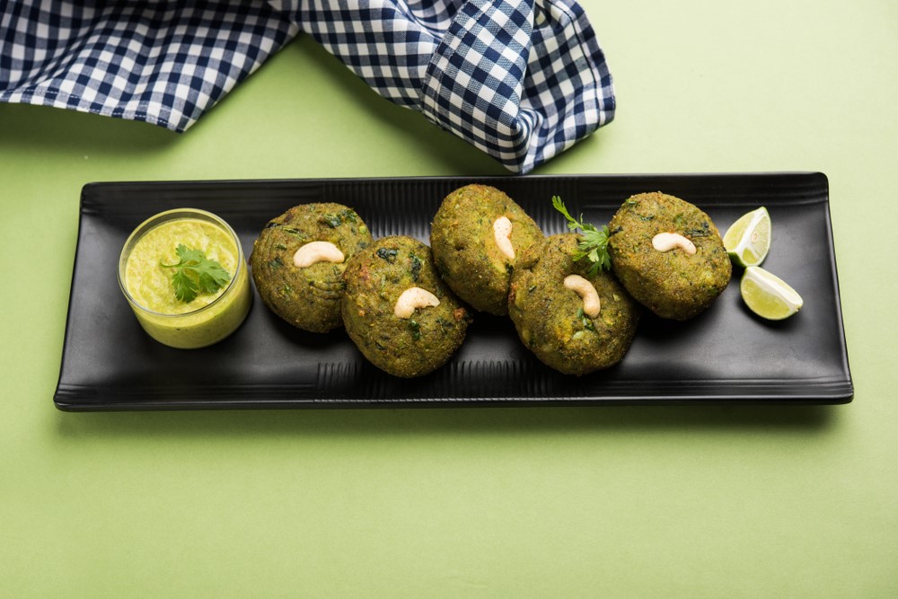 A black dish of spinach kababs