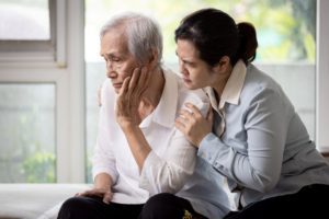 A caregiver hugging her aging parent, highlighting the idea that caregiving is not rewarding
