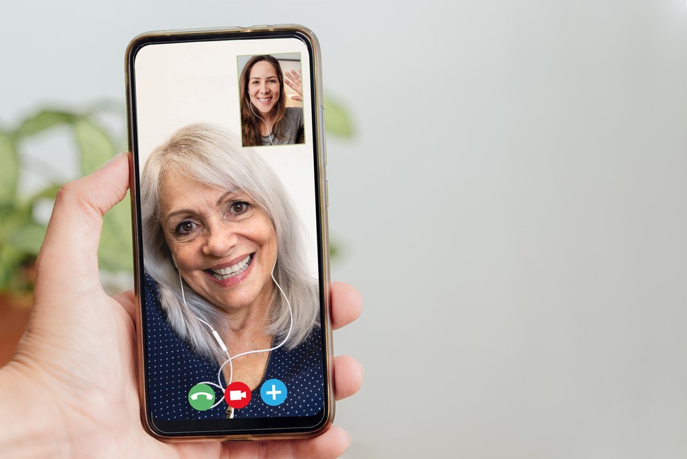 An elderly woman talking to her daughter via a mobile phone