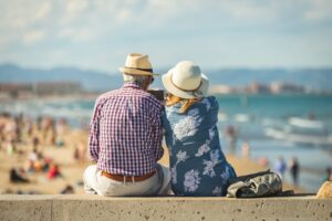 A senior couple sitting and looking out at a beach