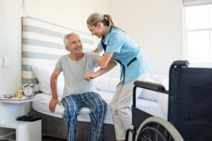 A caregiver helping a man out of bed