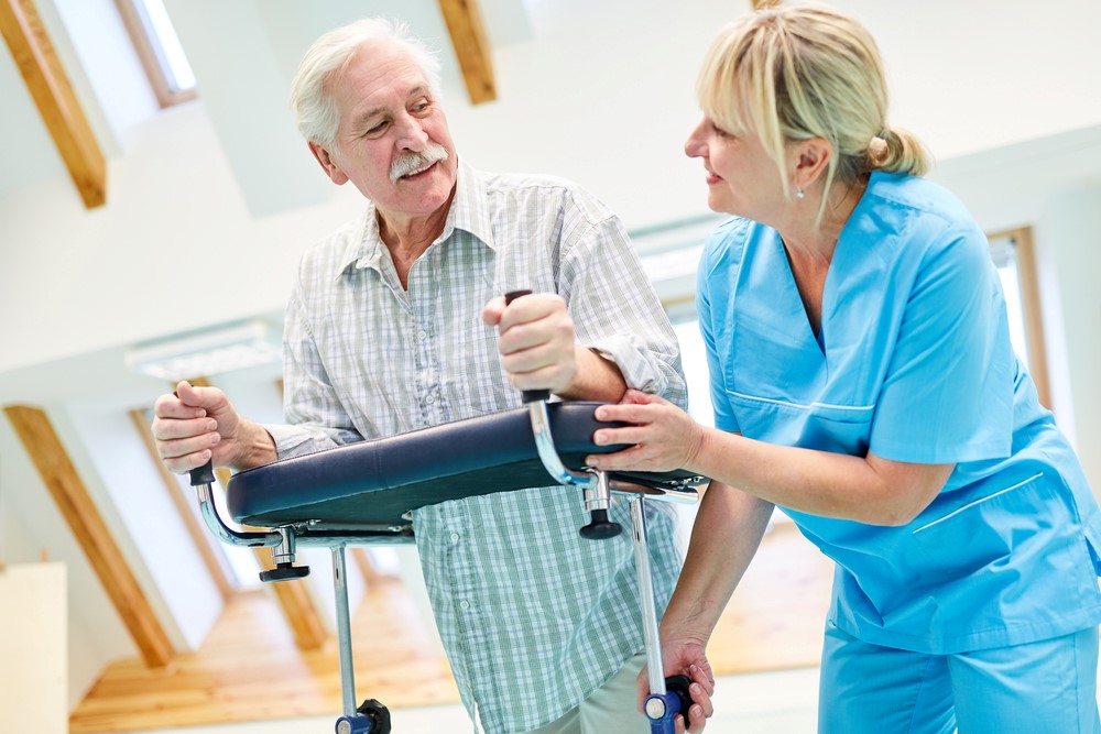 A senior man and a caregiver with a forearm support walker