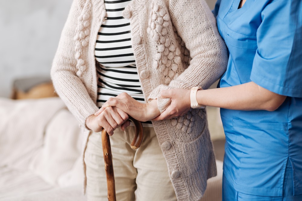 A nurse helping a senior to walk at a skilled nursing facility