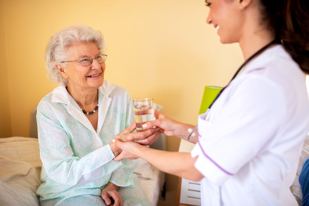 A nurse helping a senior with medication, looking at the pros and cons of a skilled nursing facility