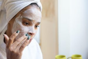 A woman using a face mask, highlighting the idea of a spa day at home, highlighting the idea of having a spa at home