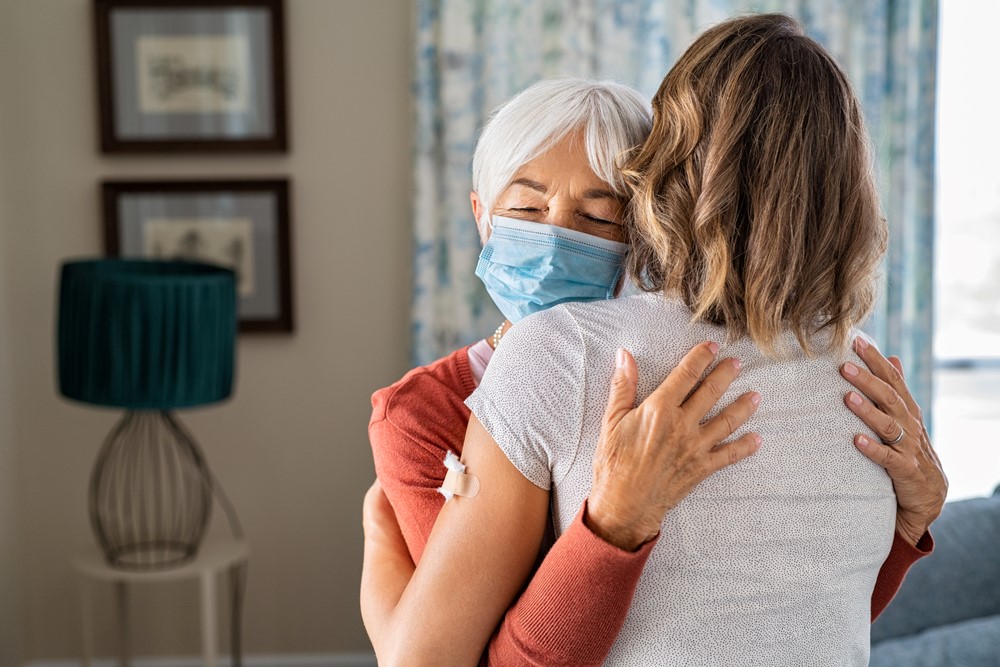 A young woman and a senior hugging