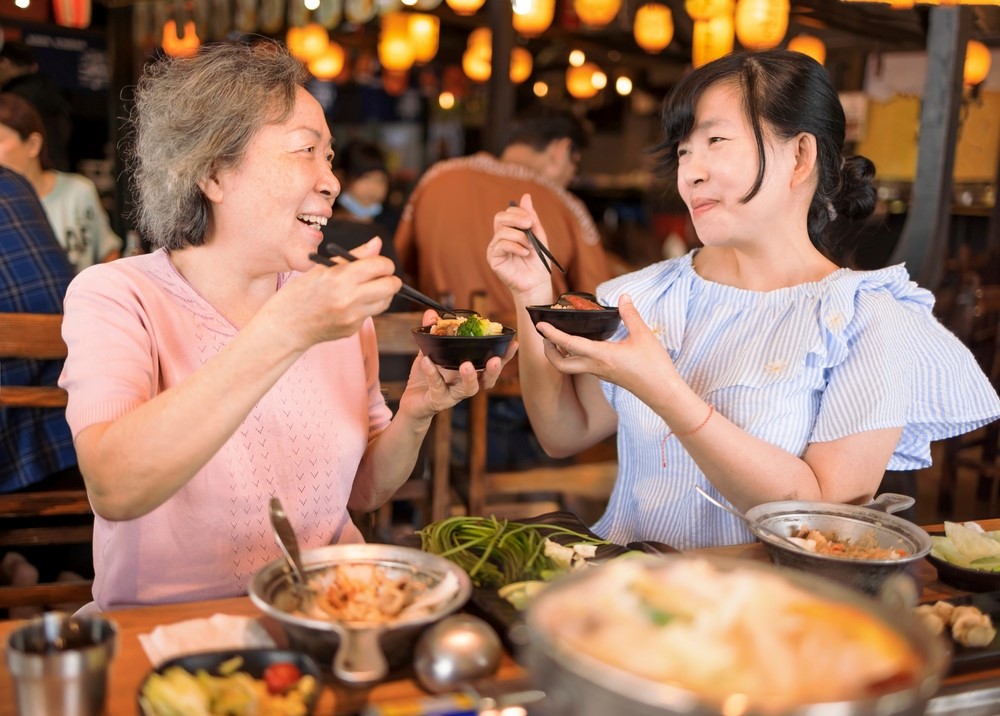 An aging mother and her daughter having dinner out