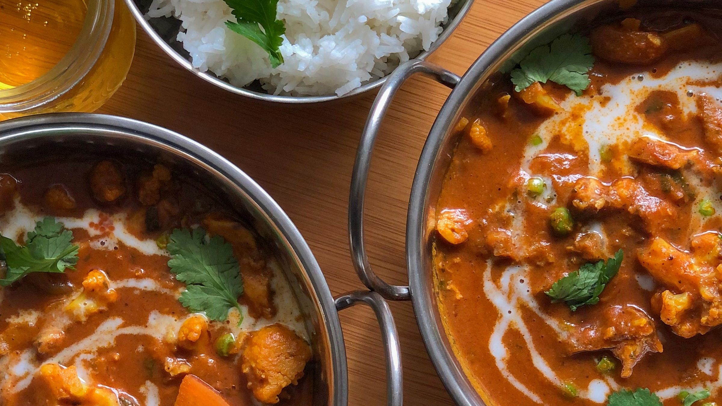 Two curries and two bowls of rice, highlighting delicious meals for elderly with no teeth