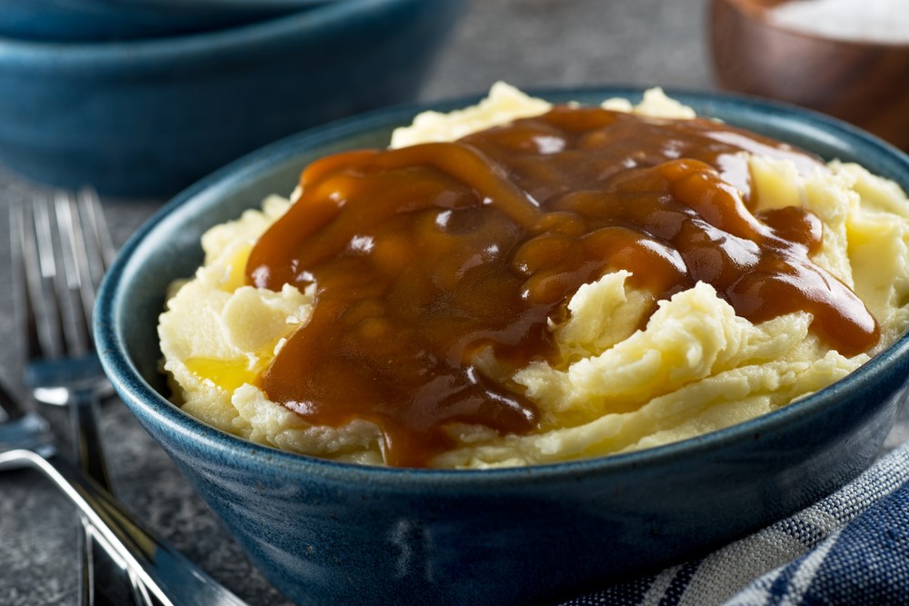 A blue bowl with potato and gravy