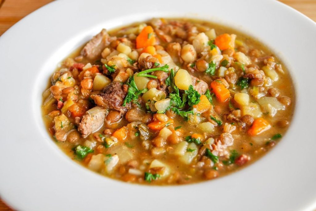 A white plate containing lentil soup