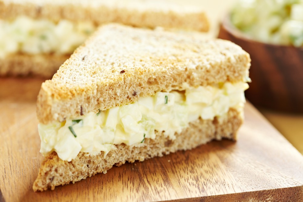 An egg sandwich on a wooden board