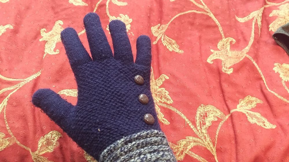 A single woolen glove against a red and gold background