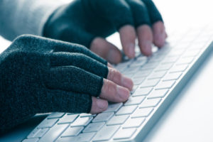 Someone typing wearing a pair of compression gloves