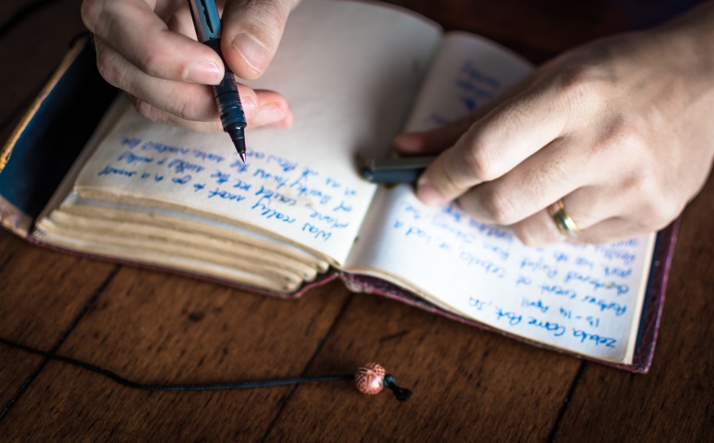 Someone writing in their journal, highlighting the benefits of writing for seniors