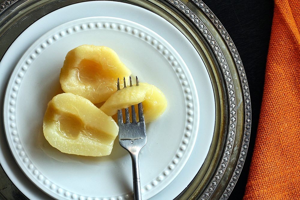 Three pears from a can on a white plate