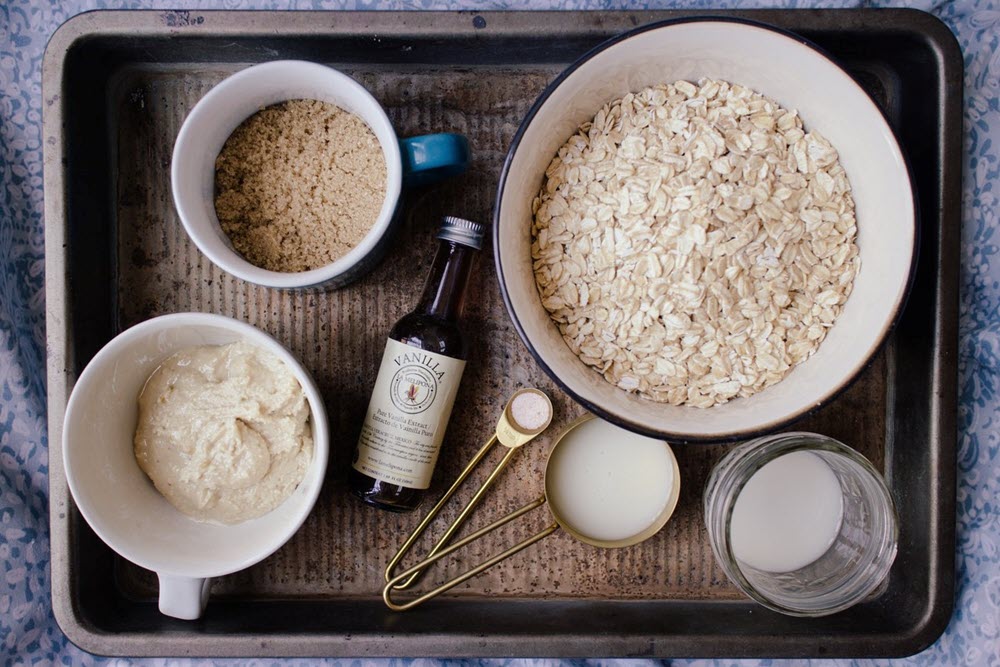 Various bowls and measuring cups containing oatmeal ingredients