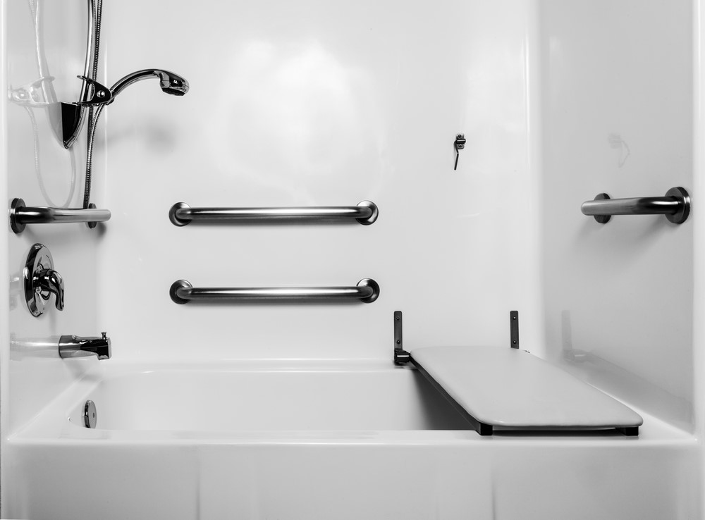 A bathroom with various grab bars and a fold out seat