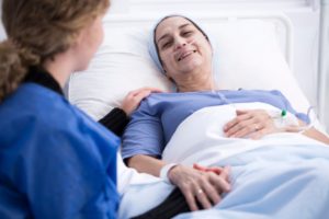 A sick woman next to her nurse, thinking about some of the problems with hospice