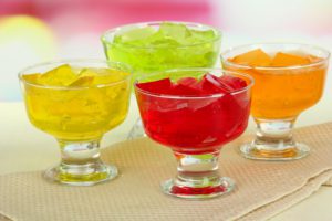 Four containers of different colored jello