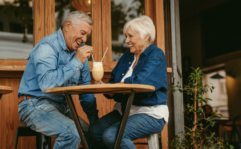 A couple drinking a shake sitting outside