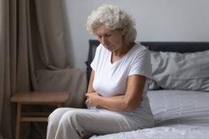 A woman sitting on her bed, highlighting the idea of constipation in seniors