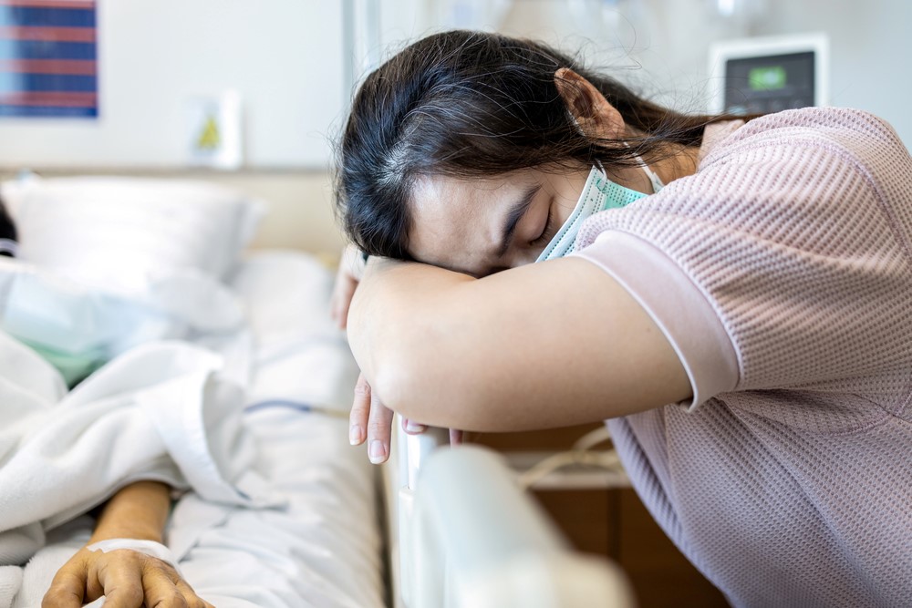 An exhausted adult daughter in a hospital room