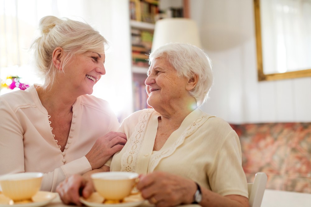 An older woman and her daughter drinking tea together, highlighting the idea of using conversation starters with older adults