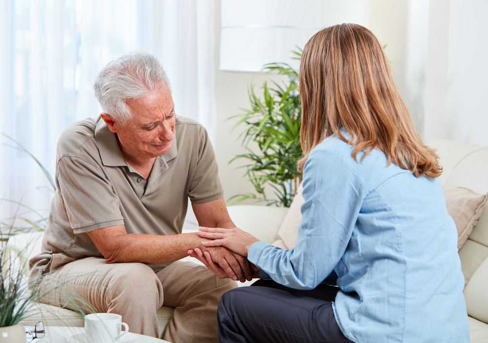 An upset senior talking to a daughter about aging at home or caregiving