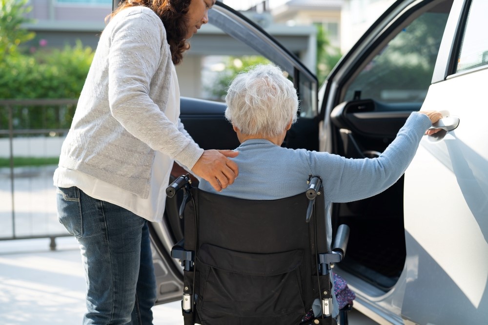 Helping a senior woman into a car