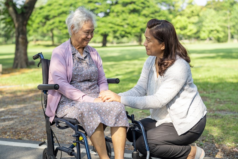 Helping an elderly woman in a wheelchair