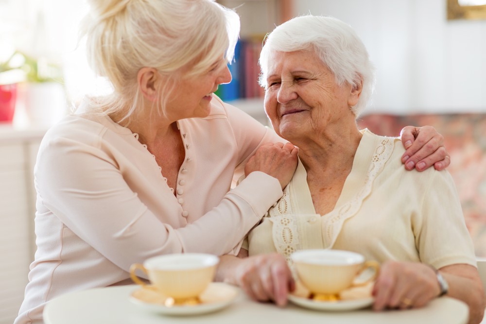 A mature woman with her senior mother having tea