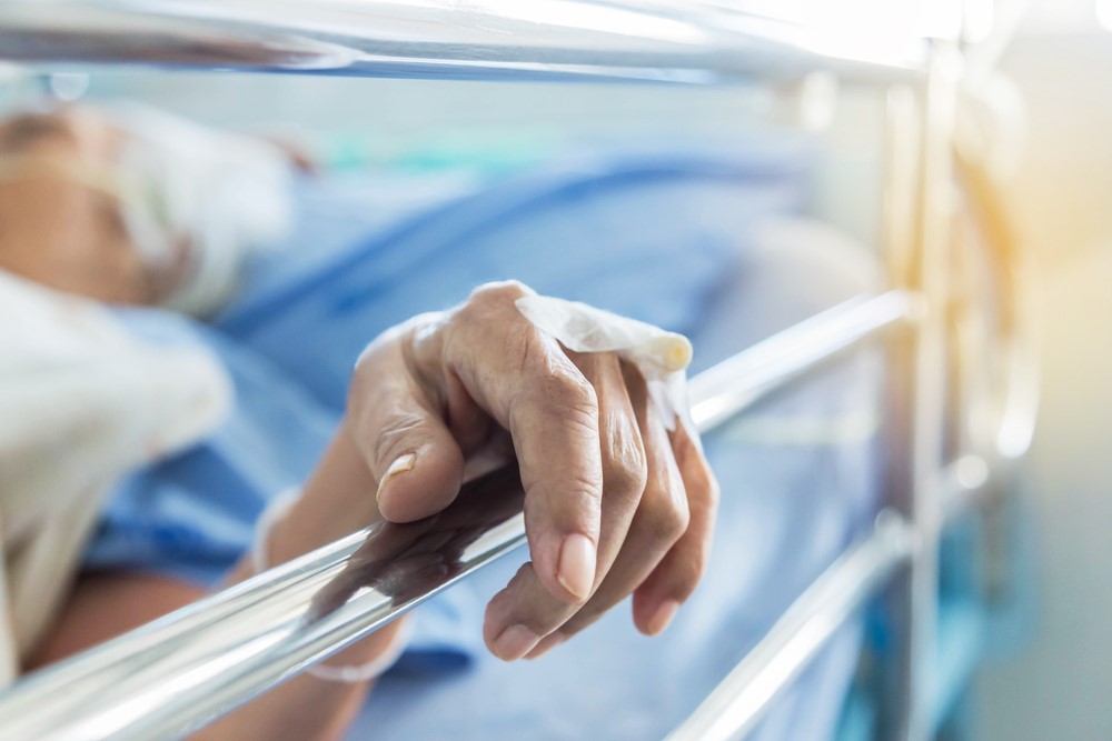 A senior woman in bed with rails