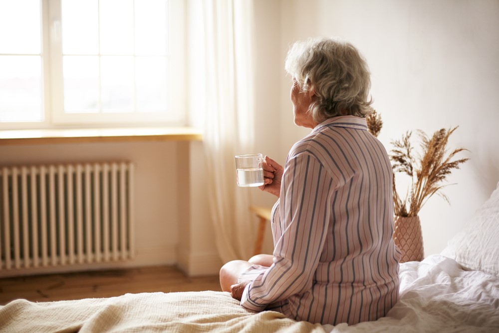 A senior woman sitting on the edge of her bed, highlighting the idea that I refuse to be my mother's caregiver