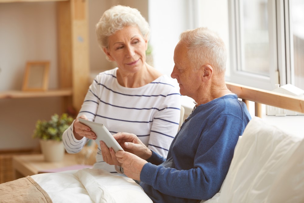 A man and his wife sitting in bed, highlighting the idea of bedroom safety for seniors