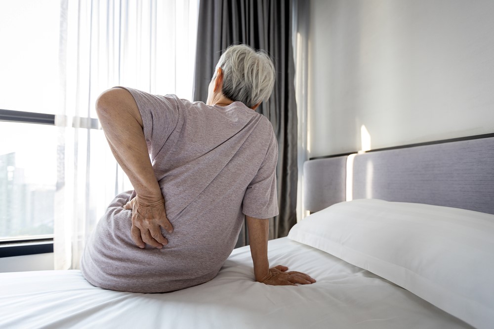 A senior woman on a bed with hip pain