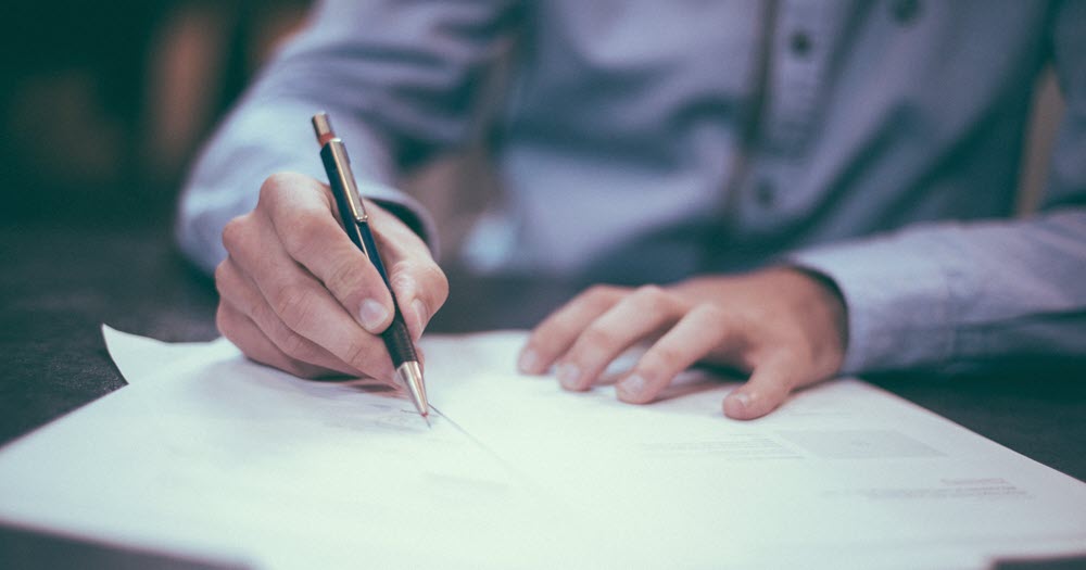 A man signing life insurance documents