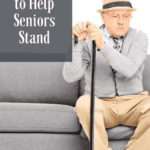 An old man sitting on a couch with a cane, suggesting that he has difficulty standing