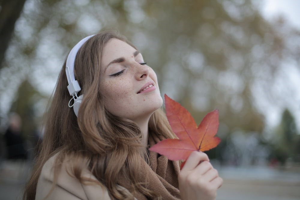 A woman with headphones and a leaf