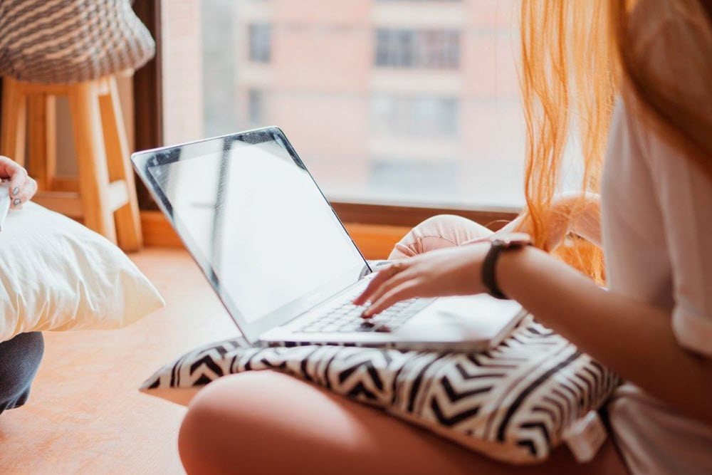 A young woman typing on a laptop