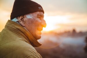 An aging man smiling at the sunset or sunrise, highlighting the question of how does dementia kill you