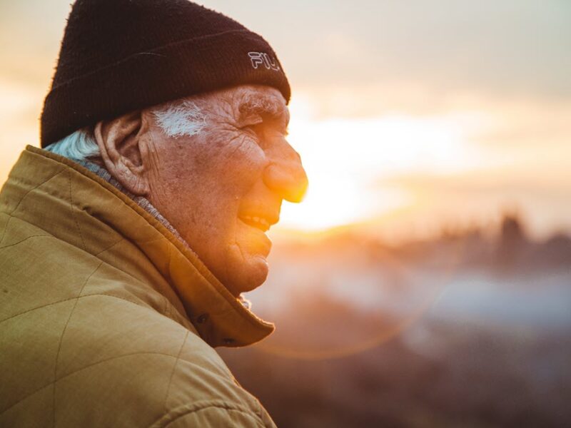 An aging man smiling at the sunset or sunrise, highlighting the question of how does dementia kill you