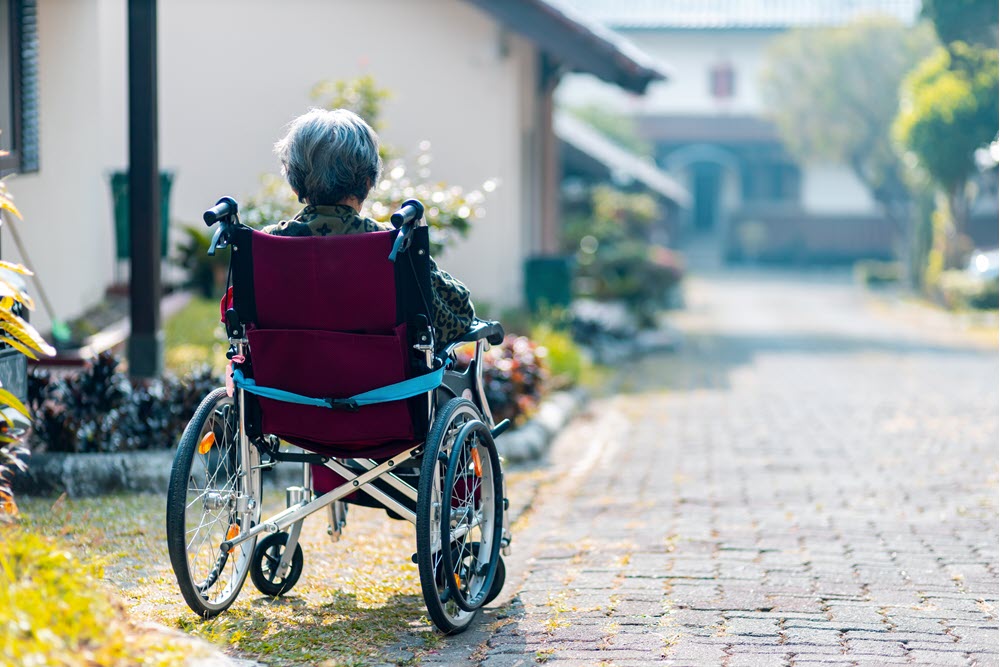 An older woman in a wheelchair, highlighting the idea of dementia or health issues